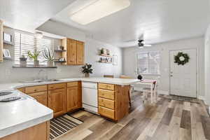 Kitchen featuring ceiling fan, kitchen peninsula, sink, white dishwasher, and a textured ceiling