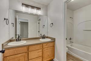 Full bathroom featuring washtub / shower combination, hardwood / wood-style floors, toilet, and vanity