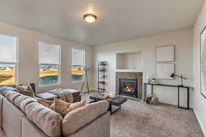 Carpeted living room featuring a tiled fireplace