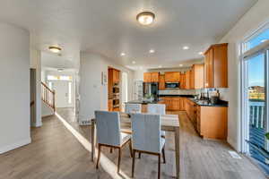 Dining room featuring sink, a textured ceiling, and light wood-type flooring