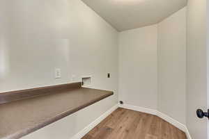 Laundry room with a textured ceiling, washer hookup, electric dryer hookup, and hardwood / wood-style floors