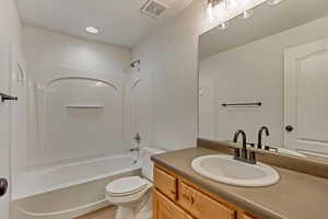 Full bathroom featuring hardwood / wood-style flooring, shower / tub combination, vanity, and toilet