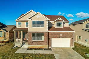 View of front of property featuring a front lawn and a garage