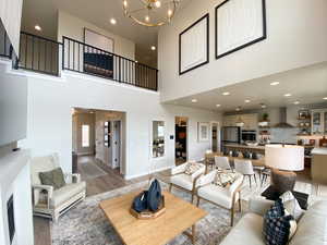 Family room with a towering ceiling, hardwood / wood-style floors, and a notable chandelier