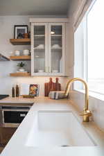 Details with stainless steel oven, backsplash, sink, and black electric stovetop