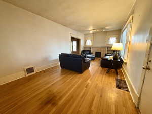 Living room with light wood-type flooring and a tile fireplace