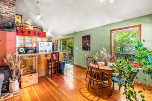 Dining area with lofted ceiling and wood-type flooring