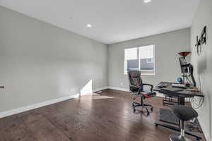 Office with dark hardwood / wood-style flooring