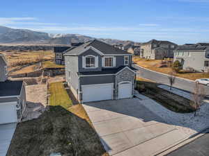 View of front facade with a front yard, a garage, and a mountain view