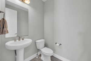 Bathroom with toilet and hardwood / wood-style flooring