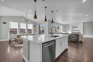 Kitchen with sink, white cabinets, dishwasher, and a kitchen island with sink