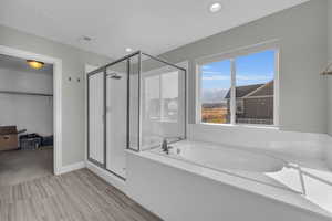 Bathroom featuring shower with separate bathtub