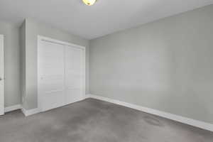 Unfurnished bedroom featuring a closet and carpet floors