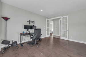 Office space with hardwood / wood-style floors and french doors