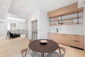 Kitchen featuring light brown cabinetry, sink, and light hardwood / wood-style flooring