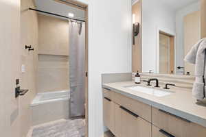 Bathroom with shower / bath combo with shower curtain and vanity