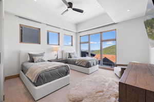 Carpeted bedroom with ceiling fan and a mountain view