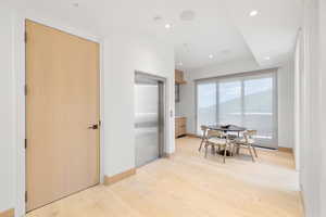 Corridor featuring light hardwood / wood-style flooring and elevator