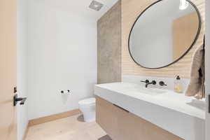 Bathroom with hardwood / wood-style flooring, toilet, and vanity