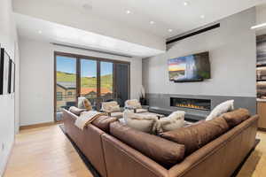 Living room with a large fireplace and light hardwood / wood-style flooring