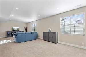 Carpeted living room with a healthy amount of sunlight