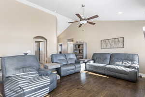 Living room with ceiling fan, dark hardwood / wood-style floors, and high vaulted ceiling