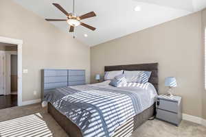 Bedroom with light carpet, ceiling fan, and lofted ceiling