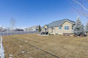 Rear view of house featuring a mountain view and a lawn