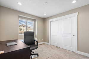 Carpeted office with a textured ceiling