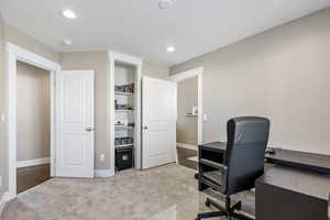 Carpeted home office with a textured ceiling