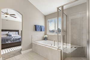 Bathroom featuring ceiling fan, tile patterned floors, lofted ceiling, and shower with separate bathtub