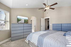 Carpeted bedroom featuring lofted ceiling and ceiling fan