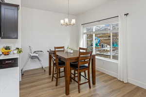 Dining space with a chandelier, a healthy amount of sunlight, and light hardwood / wood-style floors