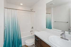 Full bathroom featuring toilet, shower / tub combo, and vanity