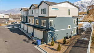 View of front of house featuring a garage, a mountain view, and central air condition unit