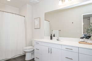 Bathroom with toilet, wood-type flooring, and vanity