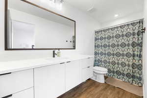 2nd bedroom attached Bathroom with hardwood / wood-style flooring, toilet, and vanity