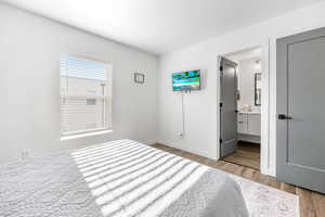 Master Bedroom with light hardwood / wood-style flooring and ensuite bath