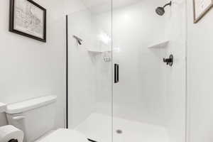 Master Bathroom with a shower with shower door and toilet