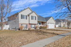 View of front of home featuring cooling unit and a garage