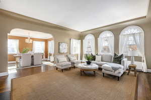 Living room with radiator, an inviting chandelier, and dark hardwood / wood-style flooring