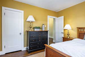 Bedroom with a closet and dark wood-type flooring