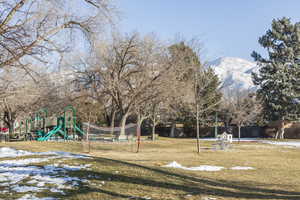 View of jungle gym with a lawn and a mountain view