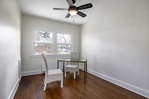 Office with ceiling fan, dark hardwood / wood-style floors, and radiator heating unit