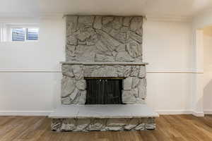 Details with hardwood / wood-style flooring, ornamental molding, and a stone fireplace