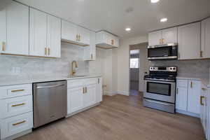 Kitchen with stainless steel appliances and white cabinetry