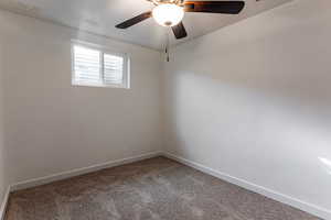 Spare room with ceiling fan and carpet flooring