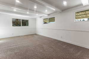 Unfurnished room featuring beam ceiling and carpet