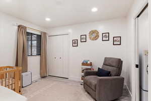 Bedroom featuring light wood-type flooring, a closet, and a nursery area