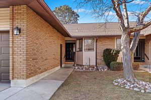 Doorway to property featuring a yard and a garage